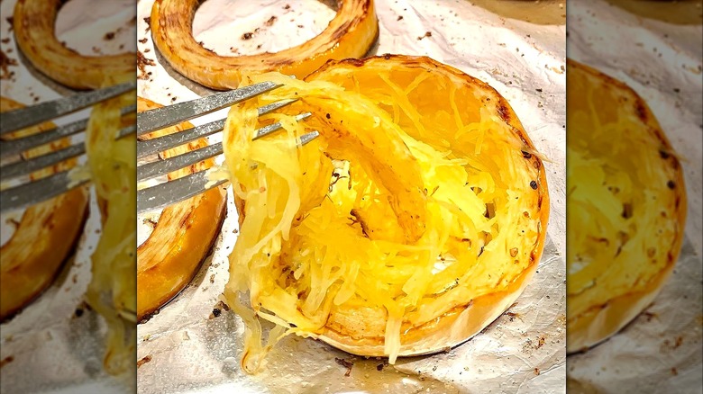 Fork removing roasted squash from individual rings