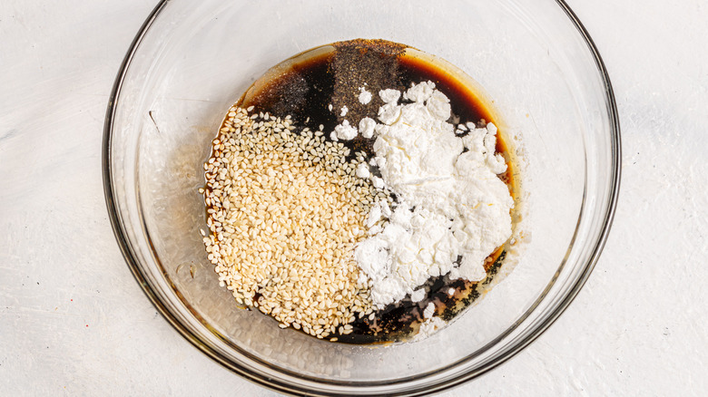 Glass bowl with soy sauce, sesame seeds, spices, and cornstarch
