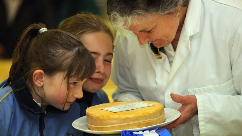 Three people smelling Stinking Bishop cheese