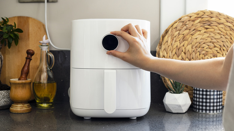 hand turning on air fryer