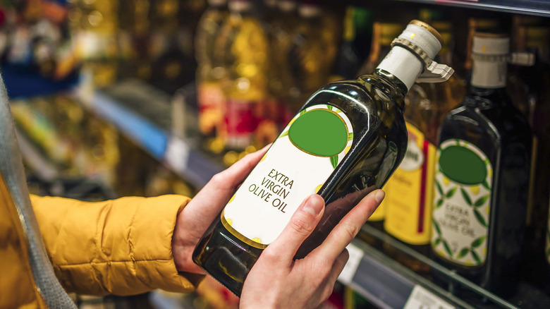 Holding bottle of olive oil