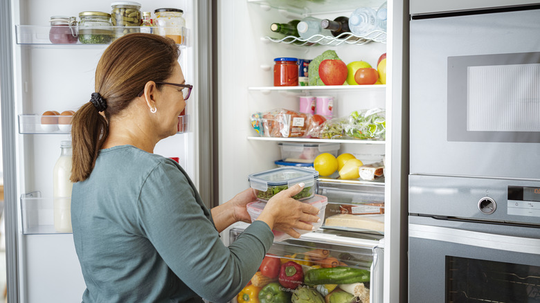 Woman putting stuff in the fridge
