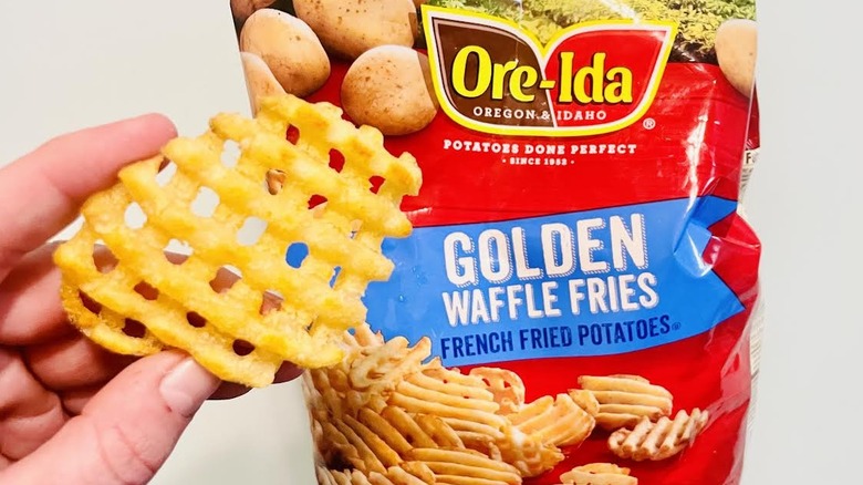 Ore-Ida Crispy Waffle Fries with hand holding a cooked one