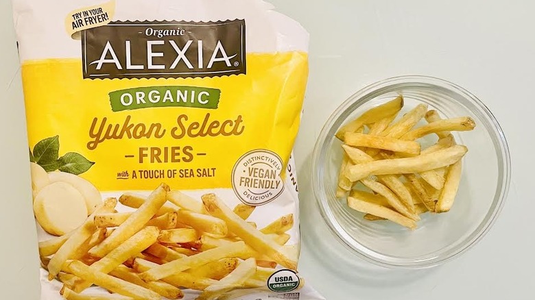 Bag of frozen Alexia Organic Yukon Select Sea Salt Fries with cooked ones on the side