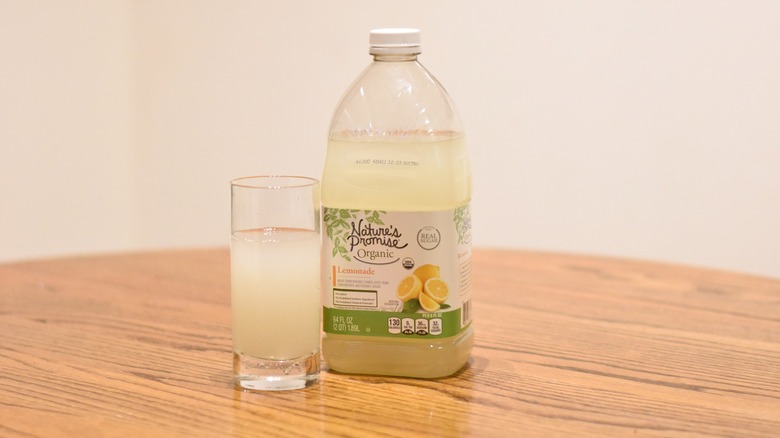 A jug of Nature's Promise organic lemonade next to a glass of lemonade