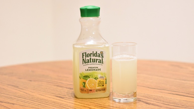 A bottle of Florida's Natural lemonade next to a glass of lemonade