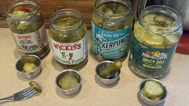 An assortment of open pickle jars with pickle samples