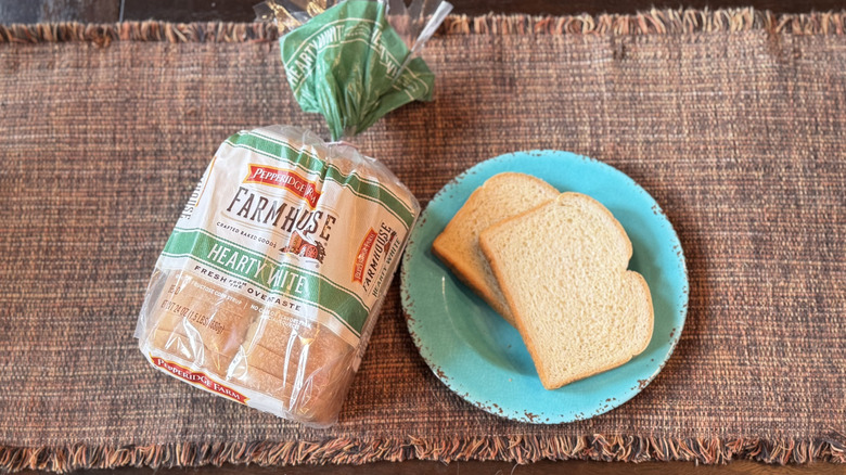 A loaf of Pepperidge Farm Bread with two slices on a blue plate