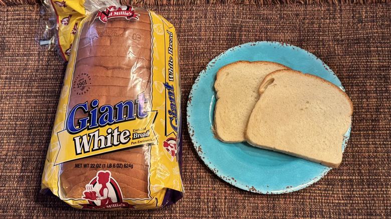 A loaf of Aunt Millie's Giant White Bread and two slices on a blue plate