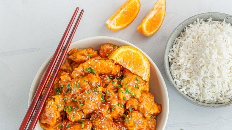 asian tangerine chicken with rice and chopsticks
