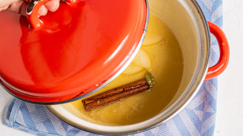 Covering a pot containing pear syrup with a lid