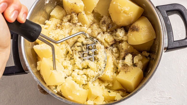 mashing potatoes in pot