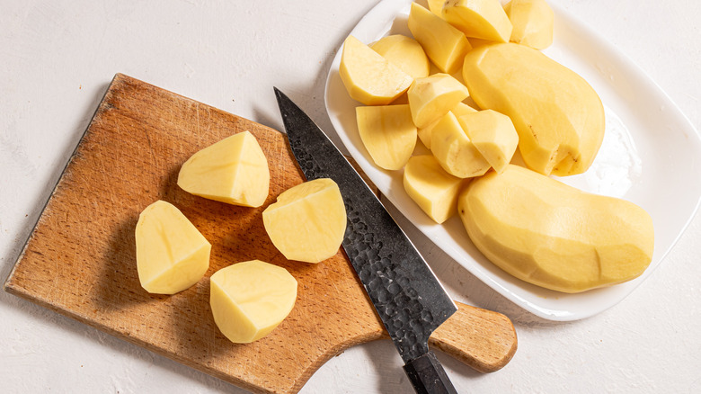 chopped peeled potatoes on board