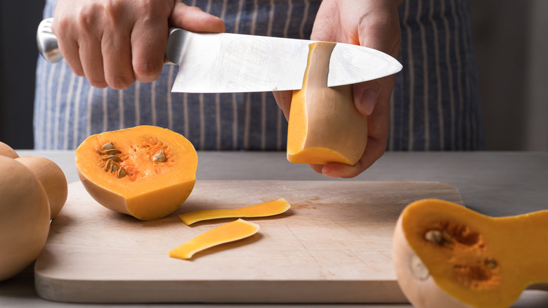 Chef cutting butternut squash with knife