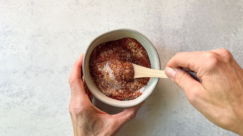 Mixing hicken and waffles spice mix in small bowl with wooden spoon