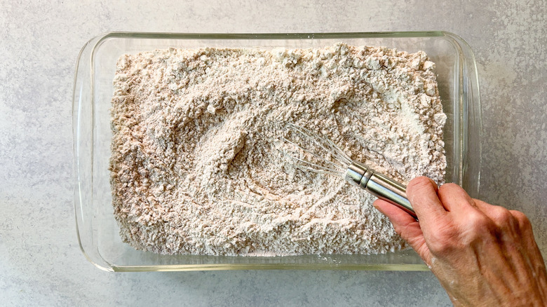 Whisking together flour, cornstarch and spices in glass baking dish