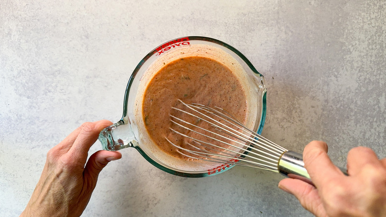 Whisking fried chicken brine in a glass measuring cup