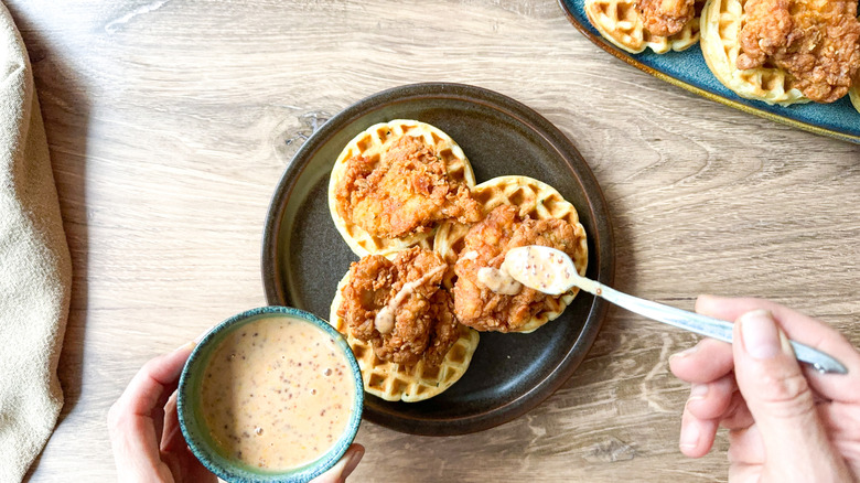 Sweet and savory crispy buttermilk chicken and waffles on plate with spicy honey mustard sauce