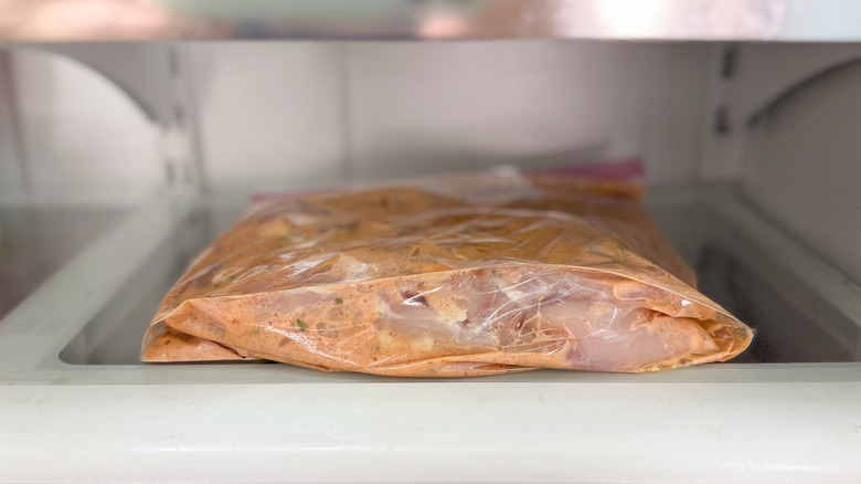 Chicken thighs in buttermilk brine in ziplock bag on refrigerator shelf