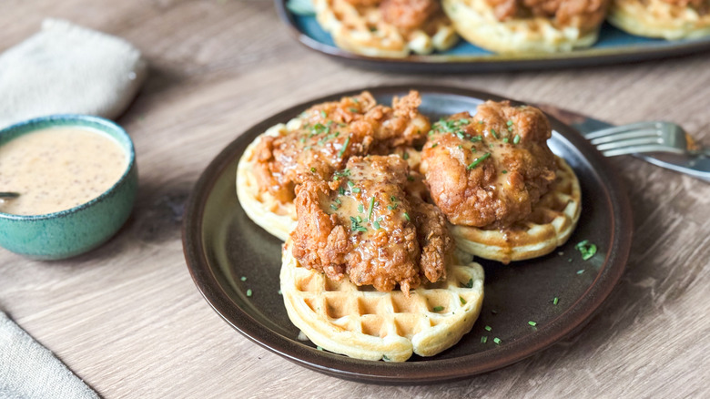 Sweet and savory crispy buttermilk chicken and waffles with spicy honey mustard on serving plate