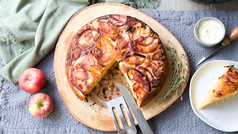 Sweet and savory upside down cornbread on cutting board with thyme, apples, and butter