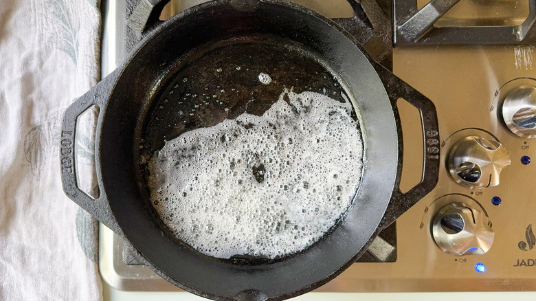 Butter melting in cast iron skillet on stovetop