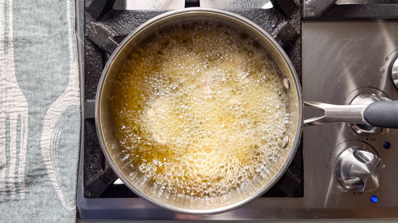 Frying chicken thigh pieces in avocado oil in pot