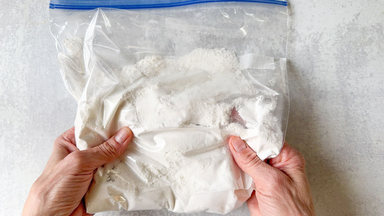 Sweet and spicy Korean fried popcorn chicken dusting flour in ziplock bag