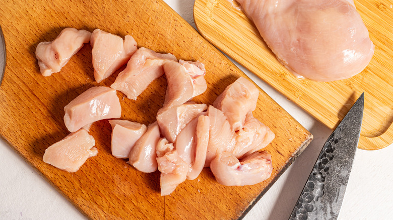 Pieces of raw chicken breast on a cutting board