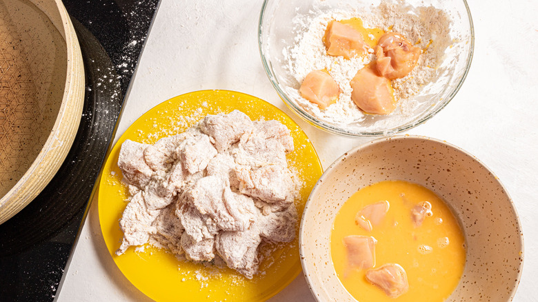 Coating chicken with egg and flour