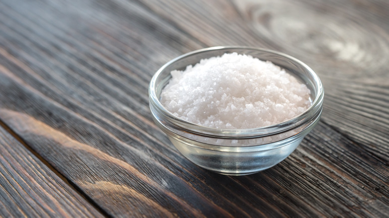 Kosher salt bowl wooden background