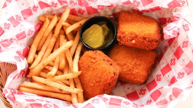 Paper-lined basket containing fries and cheese Frenchee