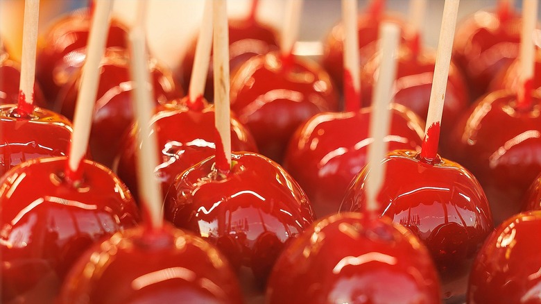 Freshly-dipped red candy apples with skewers
