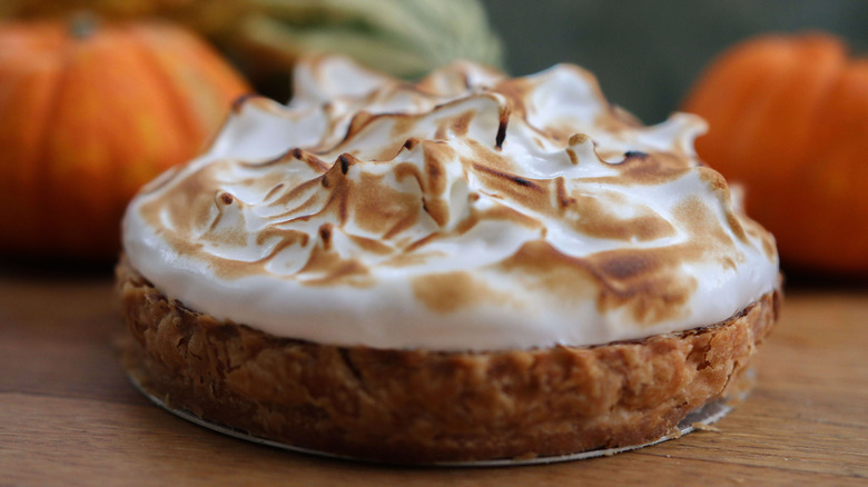 pumpkin meringue pie with pumpkins in background