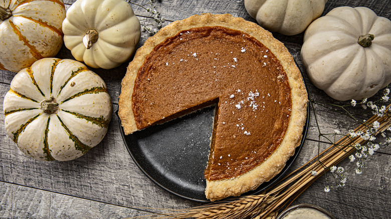 pumpkin pie sliced on tray with pumpkins