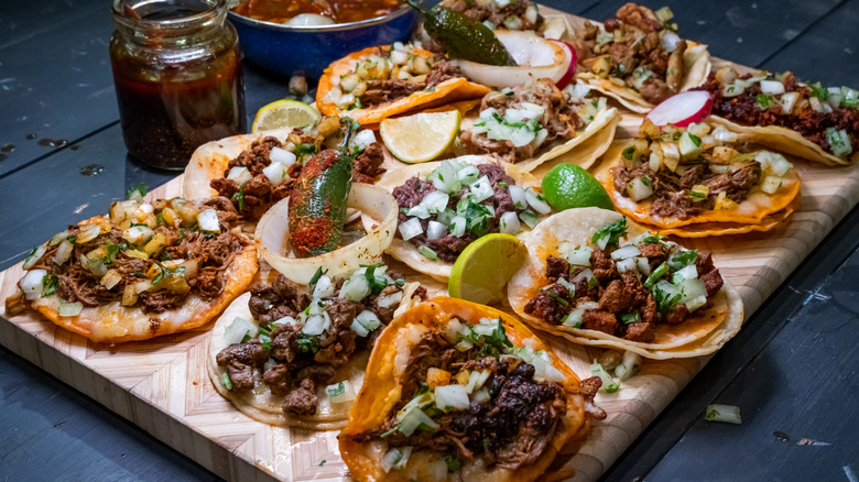 tacos with salsa and lime on wooden board
