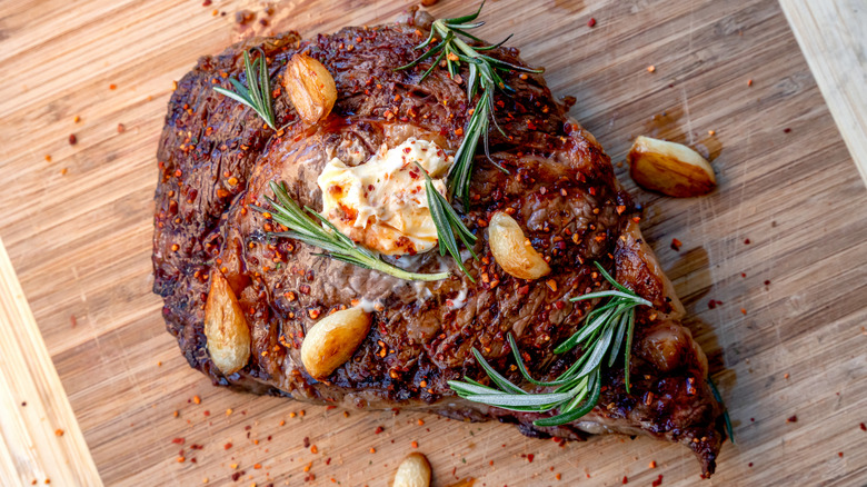 steak with garlic and rosemary on cutting board