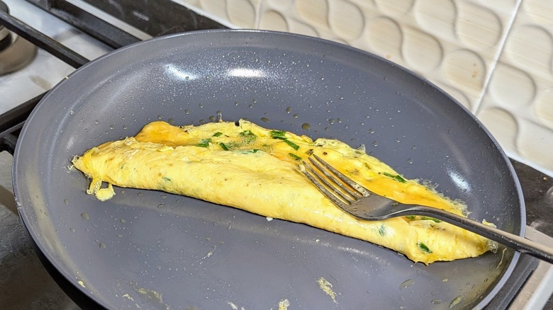 Folding French omelette with fork