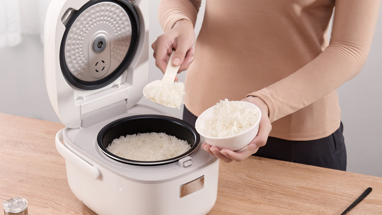 Person spooning rice out of a Toshiba Mini Rice Cooker