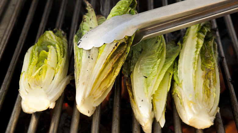 Romain lettuce and tongs on grill