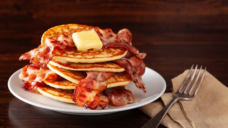 Stacked bacon and pancakes with butter