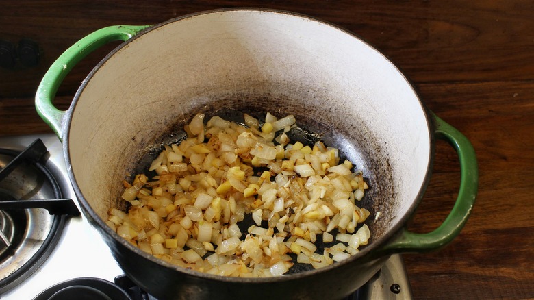 Pot with cooking onions, ginger, and garlic