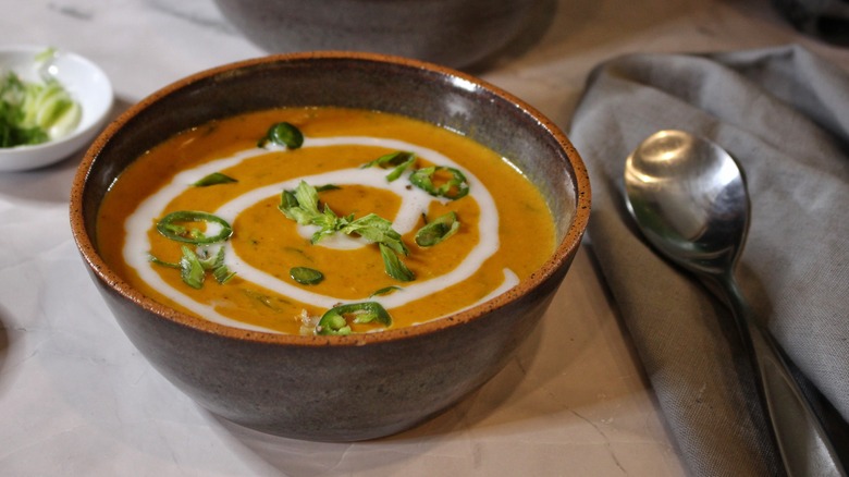 bowl of coconut pumpkin soup with basil and chiles
