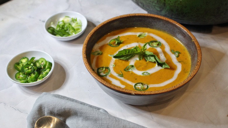 bowl of coconut pumpkin soup with chiles and basil