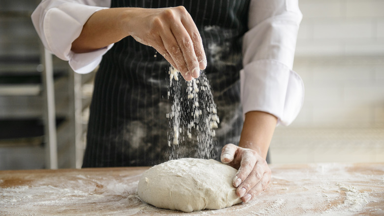 hands kneading bread dough 