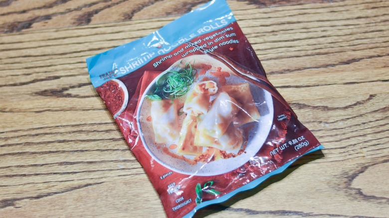 A package of shrimp noodle rolls on a wooden table