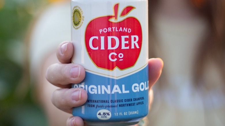 A girl holding original gold cider