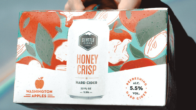 Hand holding a box of Honey Crisp ciders