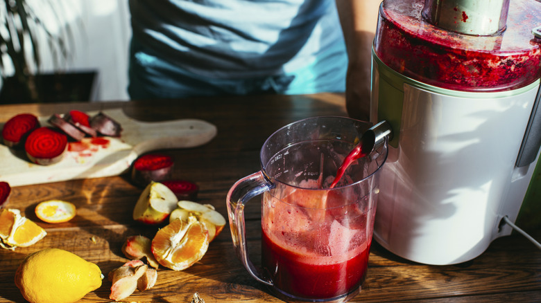 juicing table with fresh red beet and citrus juice