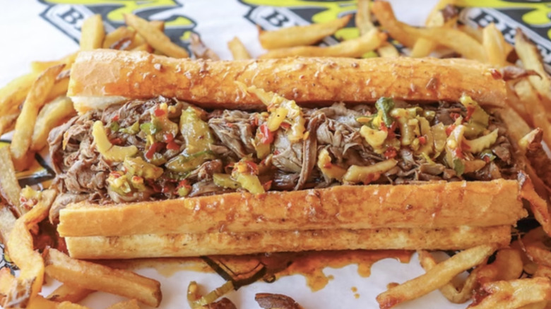 An Italian beef sandwich is displayed with french fries.